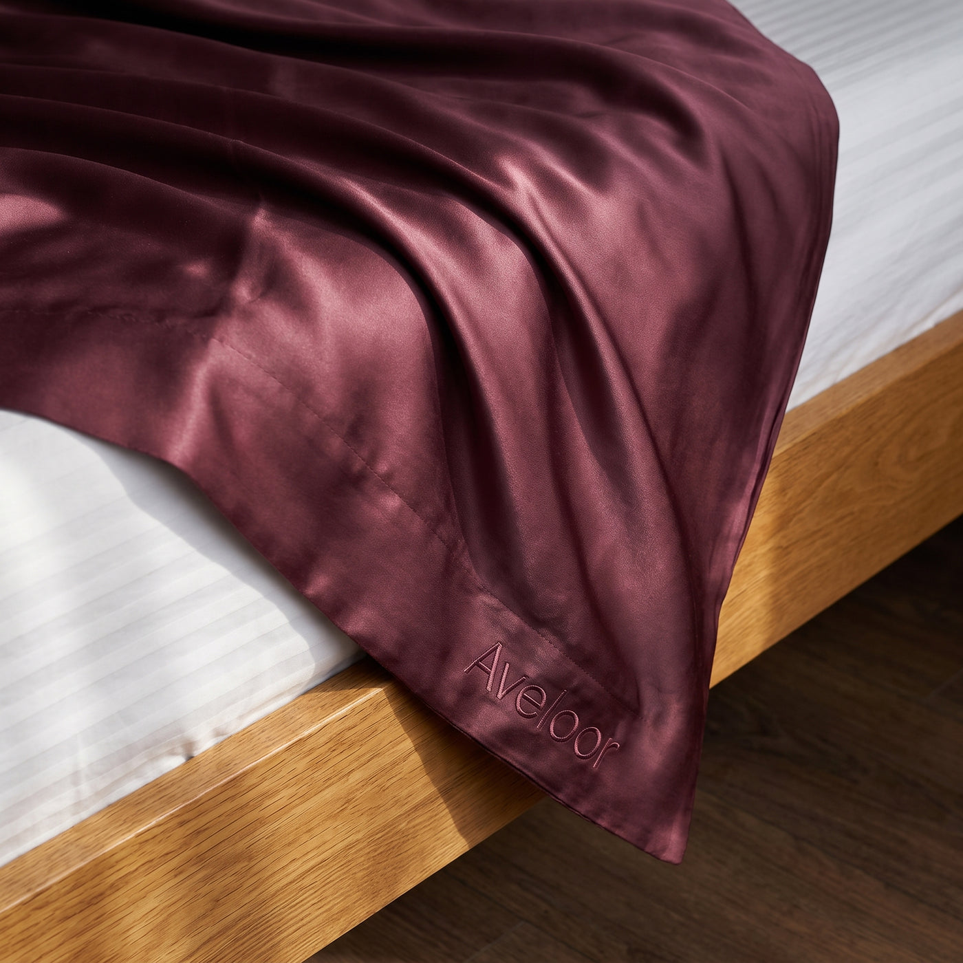 Aveloor mulberry silk pillowcase draped on a bed