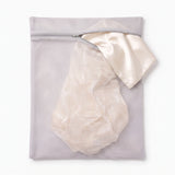 The Wash Bag close-up - ivory silk pillowcase spilling from the open zip