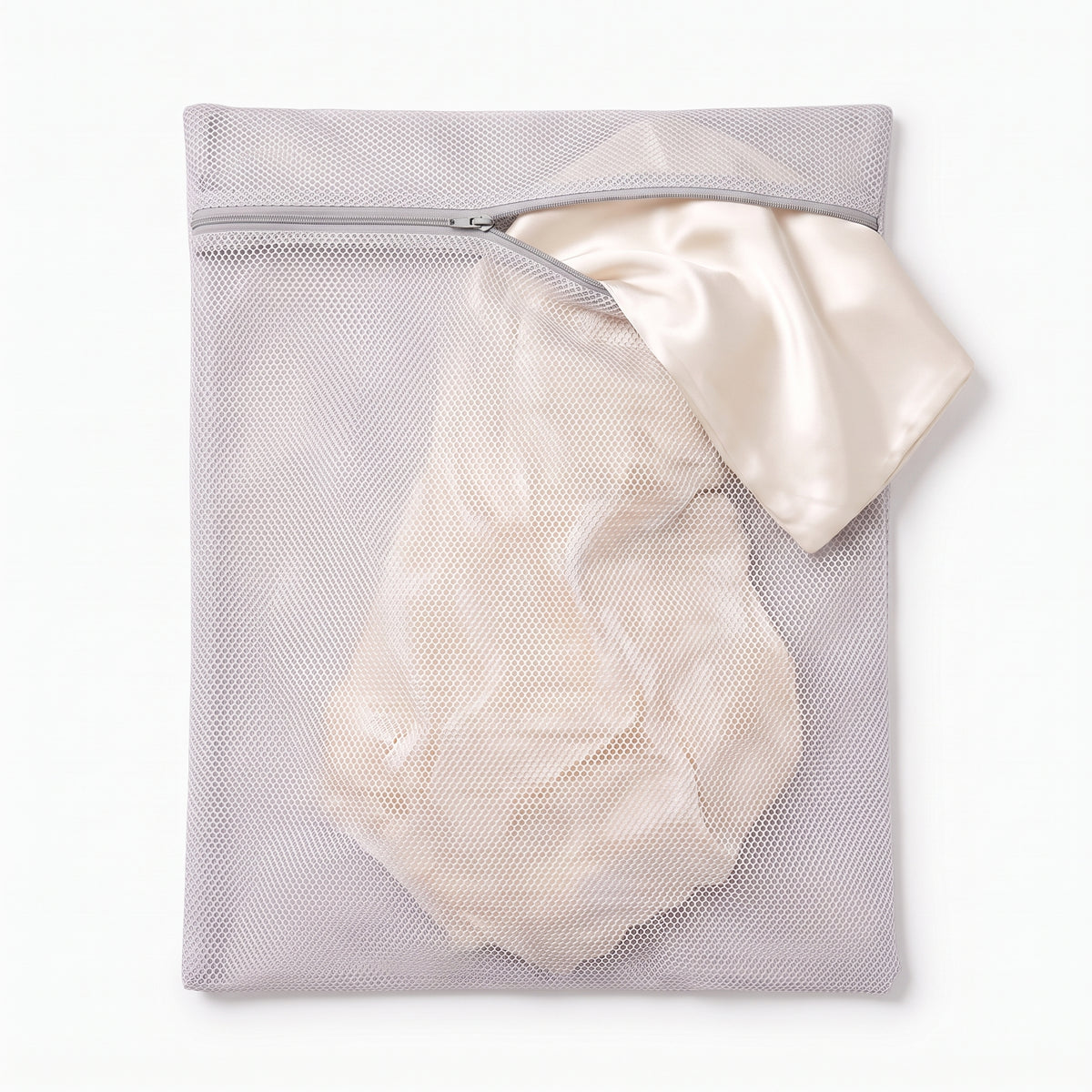 The Wash Bag close-up - ivory silk pillowcase spilling from the open zip