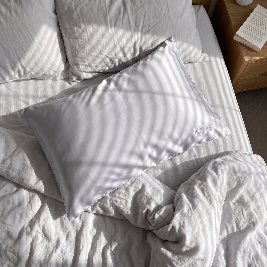 Aveloor Dove silk pillowcase - styled on a bed
