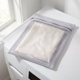 The Wash Bag resting on a washing machine, silk inside